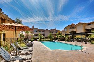 a swimming pool with chairs and an umbrella at DP-4 Ritz Pointe Condo in Dana Point