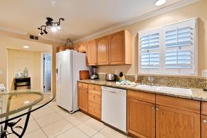 cocina con armarios de madera y nevera blanca en DP-4 Ritz Pointe Condo, en Dana Point