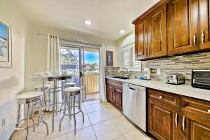 a kitchen with wooden cabinets and bar stools at Ritz Point Condo in Dana Point