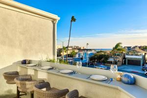 a table on a balcony with a view of the ocean at Newport Pier Townhome in Newport Beach