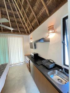 a kitchen with a sink and a bed in a room at The Reserve Tulum in Tulum