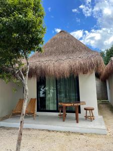 a hut with two benches and a table in front of it at The Reserve Tulum in Tulum
