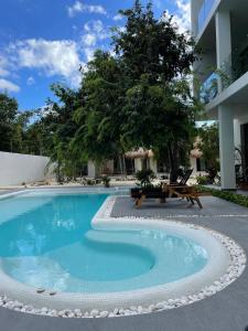 a swimming pool with a bench next to a building at The Reserve Tulum in Tulum