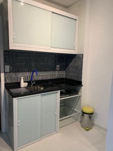 Una cocina con gabinetes blancos y un fregadero. en Angra Inn - Praia Grande 206, en Angra dos Reis