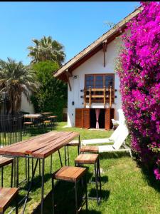 a picnic table in front of a building with pink flowers at Tanino Guest House in Mendoza