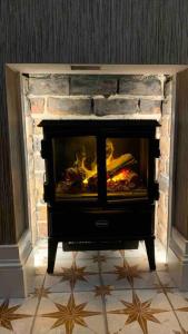 a fireplace in a living room with a fire place at ENAS COVE Homely Getaway in Derry Londonderry