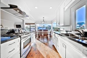 a kitchen with white cabinets and a large window at Newport Bay Front Vacation Home in Newport Beach