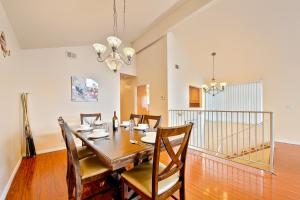 uma sala de jantar com uma mesa de madeira e cadeiras em Beach Living 1 em Newport Beach