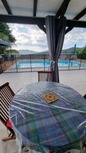 un tavolo con coperta su un patio con piscina di Les hauts du fromager a Le Diamant