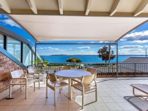 a patio with a table and chairs and a view of the ocean at A Yachtsmans Rest, Unit 4/37 Victoria Parade in Nelson Bay