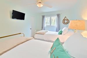 een slaapkamer met 2 bedden en een flatscreen-tv bij Seashell Cottage in San Diego