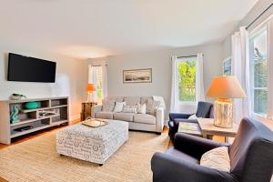 een woonkamer met meubilair en een flatscreen-tv bij Seashell Cottage in San Diego