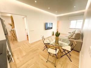 a living room with a glass table and chairs at Apartamentos SweetHomes in Faro