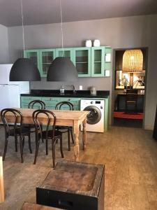 a kitchen with green cabinets and a table and chairs at Bungalows Demetria in Guadalajara