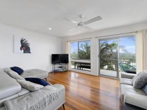 a living room with two couches and a flat screen tv at Emerald Views Signal Street 9 in Emerald Beach