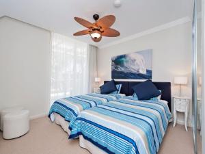 1 dormitorio con 2 camas y ventilador de techo en Aura Apartments Unit 12 59 Shoal Bay Road, en Shoal Bay