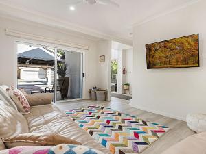 a living room with a couch and a painting on the wall at Belli Street 3 in Noosa Heads