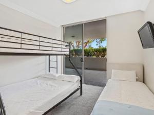 a bedroom with two bunk beds and a balcony at Aura Apartments Unit 5 59 Shoal Bay Road in Shoal Bay