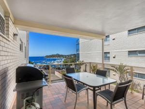 un patio con parrilla, mesa y sillas en Laman Lodge Unit 2 15 Laman Street en Nelson Bay