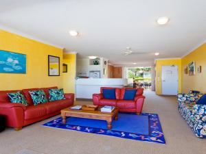 a living room with two red couches and a coffee table at Cote DAzur 6 Douglas Street 6 in Sunshine Beach
