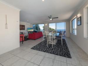 a dining room and living room with a table and chairs at Laman Lodge Unit 5 15 Laman Street in Nelson Bay