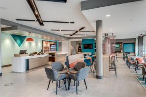 a lobby with chairs and tables and a counter at avid hotels - Zeeland by IHG in Holland