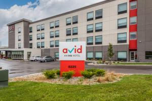 avid hotels - Zeeland, an IHG Hotel في هولاند: مبنى مكتب أمامه لوحة