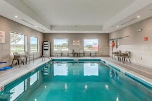 a swimming pool with chairs and tables in a building at avid hotels - Zeeland by IHG in Holland