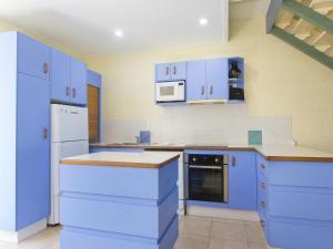 a blue kitchen with white appliances and blue cabinets at Kareela Court 3 Kareela Avenue 14 in Noosa Heads
