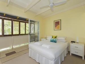 a white bedroom with a bed and a window at Kareela Court 3 Kareela Avenue 14 in Noosa Heads