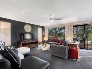 a living room with a couch and a tv at Horizons Escape Villa 136 in Salamander Bay