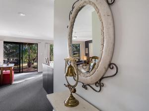 un espejo colgado en una pared en una sala de estar en Horizons Escape Villa 136 en Salamander Bay