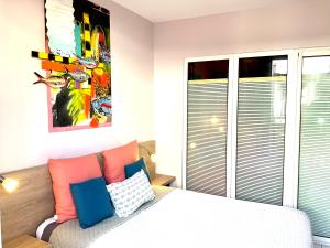 a bedroom with a bed with orange and blue pillows at Le Patio Foyalais in Fort-de-France