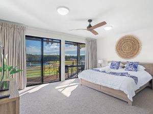 1 dormitorio con cama y ventana grande en Horizons Fairway Views Townhouse 108, en Salamander Bay