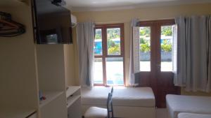 a living room with a bed and a window at APARTAMENTO 3 quartos no Taperapuan Duplex 450 mt da praia in Porto Seguro
