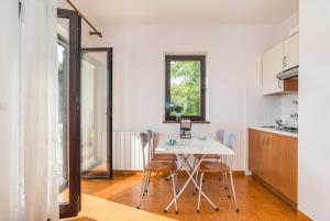 a kitchen and dining room with a table and chairs at Apartments Vienna in Zambratija
