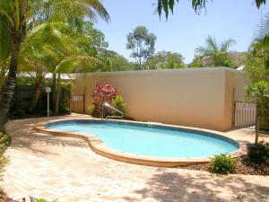 a swimming pool in a yard next to a building at Noosa River Gardens 1 Hilton Terrace 76 in Tewantin