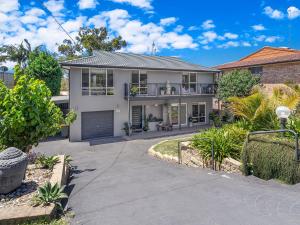 a white house with a balcony and a driveway at Private coastal getaway Corlette in Corlette