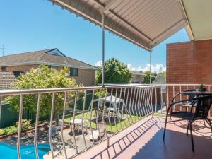 a patio with a deck with a table and chairs at Tamara Court in Sawtell
