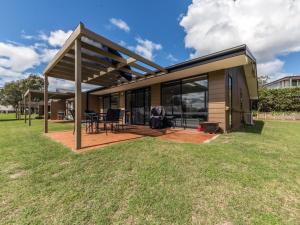 a small house with a deck and a patio at Horizons Golf Club Villa 124 in Salamander Bay