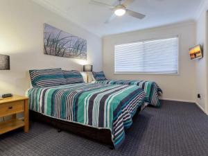 a bedroom with two beds and a window at Horizons Golf Club Villa 124 in Salamander Bay