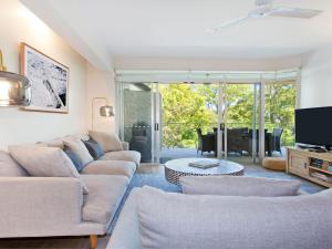 a living room with a couch and a tv at Park Cove 4 Park Road 48 in Noosa Heads