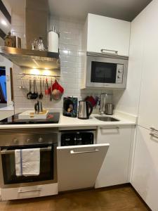 a kitchen with a stove and a microwave at Don Quijote in Toledo