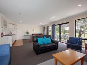 een woonkamer met een bank, stoelen en een tafel bij Horizons Golf Club Villa 135 in Salamander Bay