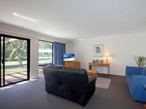 een woonkamer met een bank en een televisie bij Horizons Golf Club Villa 135 in Salamander Bay