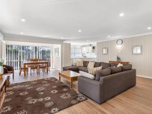 a living room with a couch and a dining room at Bay Serene 15 Mistral Close in Nelson Bay
