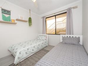 a bedroom with two beds and a window at Bay Village Unit 2 47 Shoal Bay Road in Shoal Bay