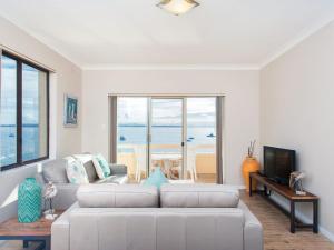 a living room with a white couch and a television at Bay Village Unit 6 47 Shoal Bay Road in Shoal Bay