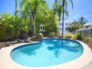 a large swimming pool in a yard with palm trees at Weyba Quays Townhouse 7 Peza Court 6 in Noosa Heads