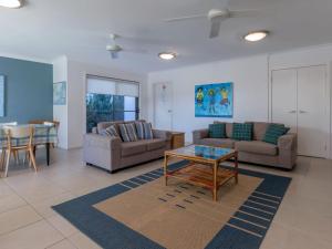 a living room with two couches and a table at Beach House 1 20 Pacific Drive in Fingal Bay